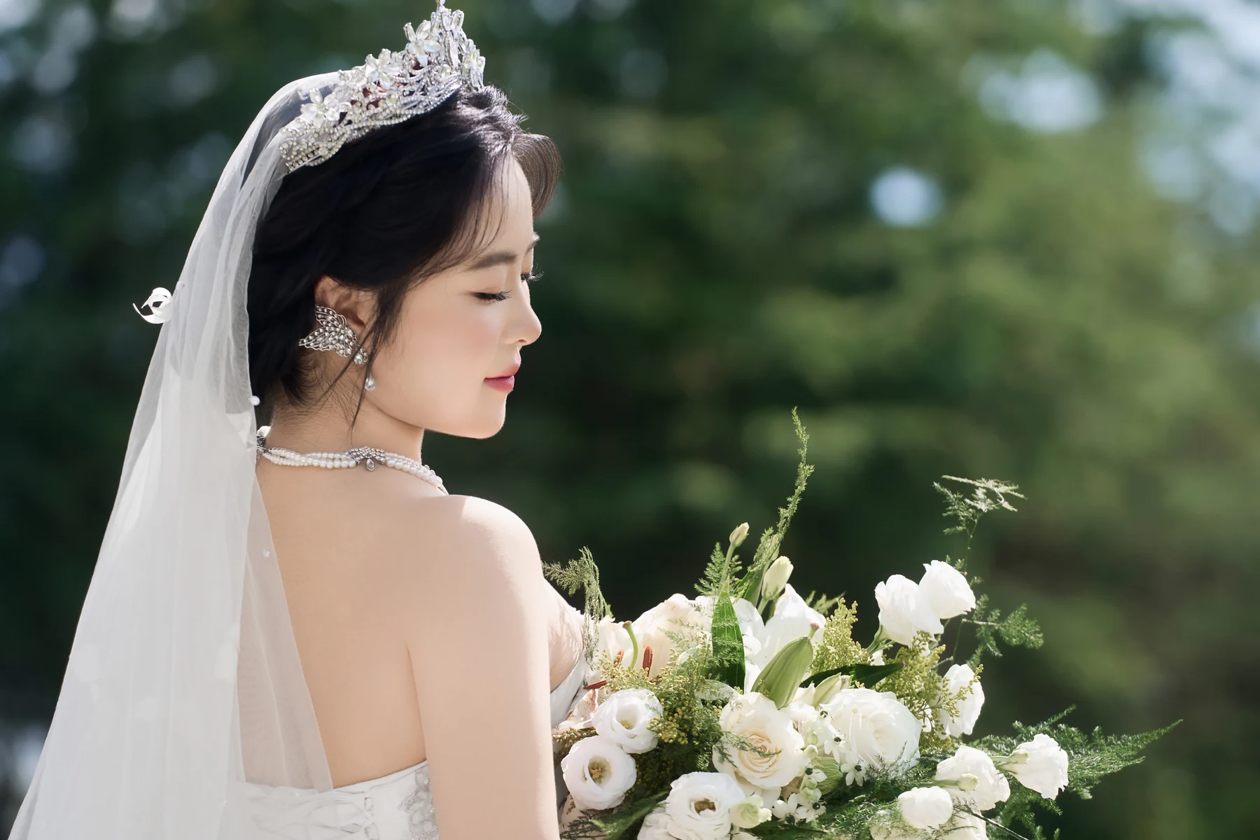 原宝钦戴着皇冠、手捧白色鲜花的婚纱照